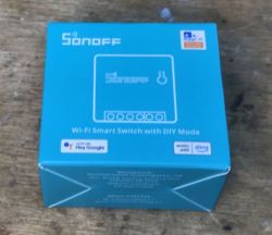 Sonoff Mini R2 Package Sonoff Mini R2 package lying on a wooden table.