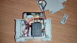 Opened casing with visible electronics and connected wires.
