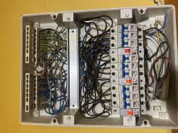 Rozdzielnica elektryczna z szeregiem wyłączników nadprądowych i ułożonymi przewodami