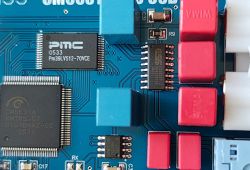 Zbliżenie płytki PCB DAC z układami PMC Pm39LV512 i CM6631A oraz czerwonymi kondensatorami WIMA