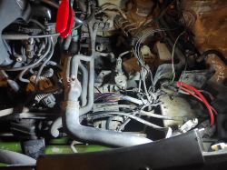 Damaged wiring harness above the starter in a car engine bay