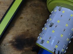 Zbliżenie na wnętrze lampki kempingowej z widocznymi diodami LED.