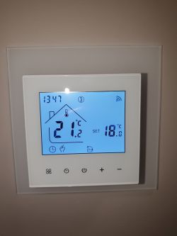 Wi-Fi thermostat mounted on wall showing 21.2°C and 18.0°C on display