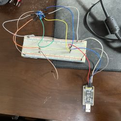Breadboard with connected wires, electronic module, and USB programmer.
