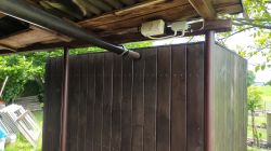 Wooden structure with a roof and a pipe mounted to the wall.