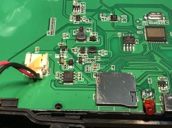 Zbliżenie na płytkę obwodu drukowanego z różnymi elementami elektronicznymi, w tym złączem kart microSD.