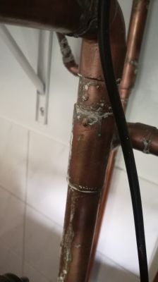 What Causes Sediment Deposits on Copper Pipes in a Central Heating System?