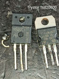 Dwa komponenty elektroniczne leżące obok siebie na czarnej powierzchni, z widocznymi numerami modeli.