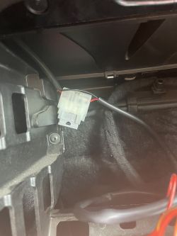 Plastikowe złącze elektryczne z czerwonymi przewodami w samochodzie