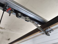 Mechanizm prowadnicy i ramienia bramy garażowej z widocznym mocowaniem