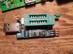 CH341A USB programmer with ZIF socket and flash chip on wooden surface