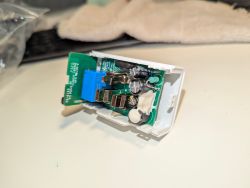 Electronic circuit board in a case A printed circuit board with electronic components in a white case on a table.