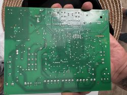 Spód zielonej płytki PCB z zaznaczonym pustym miejscem po brakującym elemencie.