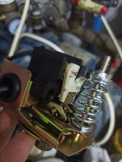 Zbliżenie na część mechaniczną z dużą sprężyną i elementem elektrycznym.