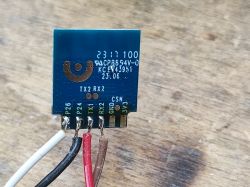 Electronic module with connected wires on a wooden surface.