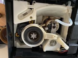Close-up of the interior of a Krups coffee machine with brewing components and coffee residue.