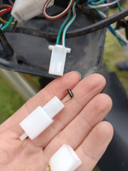Dłoń trzymająca plastikowe złącze z przymocowaną diodą prostowniczą