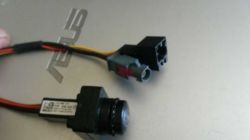 Kamera cofania z przewodami i złączami na tle laptopa.