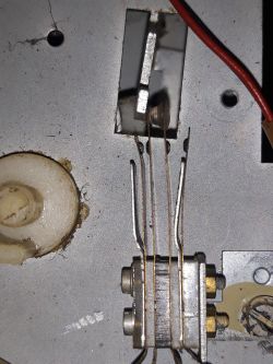 Wnętrze urządzenia elektronicznego z widocznymi przewodami i elementami metalowymi.
