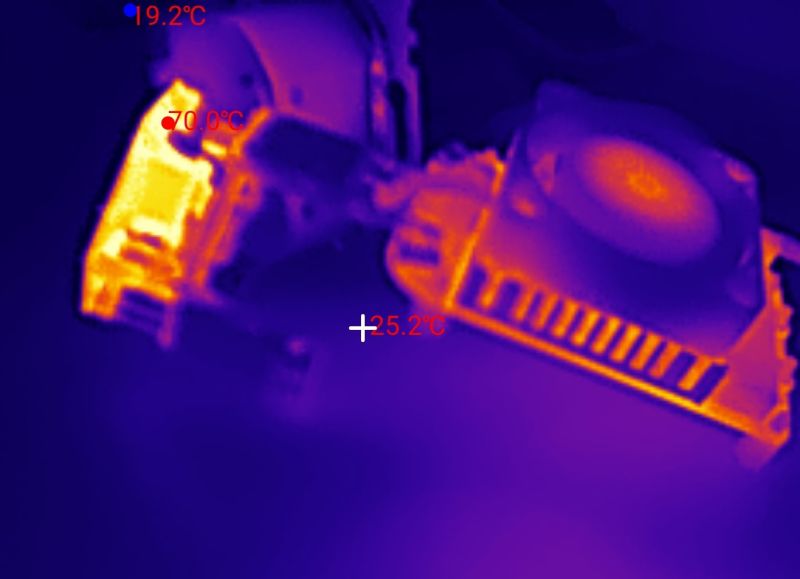 Thermal camera view of electronics on a table; hotspot labeled about 70.0°C and a 19.2°C reading