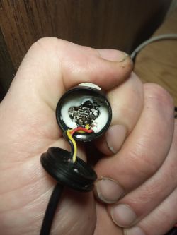 Ręka trzymająca otwartą obudowę z widocznymi przewodami i elektroniką.
