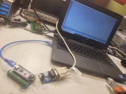 Laptop Dell z wykresem oraz płytki Arduino połączone przewodami na stole warsztatowym