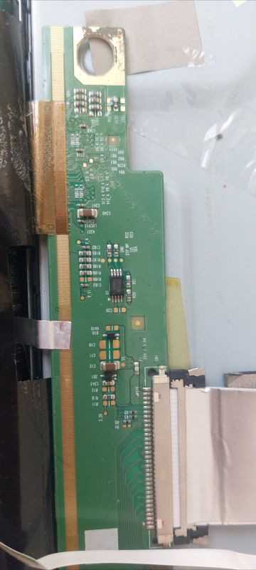Close-up of a green PCB with SMD components and a ribbon cable connector