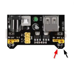 Power module with USB output and power connector, polarity marked with arrows.
