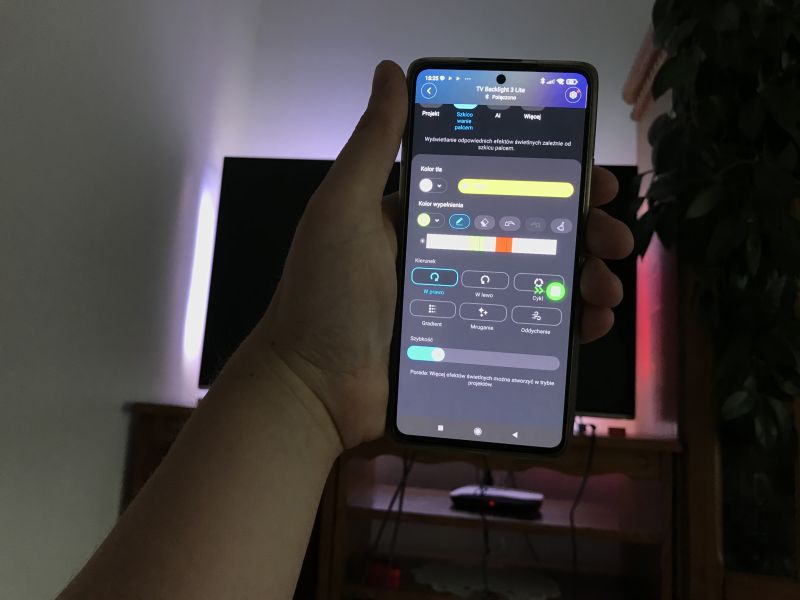Phone with LED backlight control app in front of a TV with ambient lighting