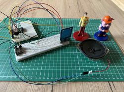 Prototyp układu elektronicznego z ESP32, czytnikiem RFID RC522 i figurkami z tagami RFID na macie montażowej.