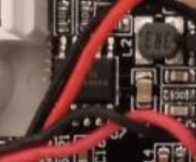 Close-up of a PCB with red wires and a small SMD integrated circuit
