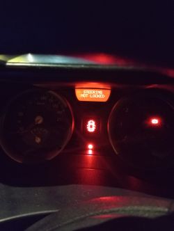 Deska rozdzielcza samochodu z komunikatem „Steering not locked”.