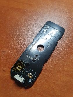 Electronic board of a Tuya door sensor with visible circuits and connectors on a brown background.