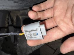 Zbliżenie na szary plastikowy wtyk z przewodami do lampy przeciwmgielnej BMW X3 E83