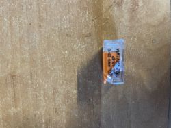 Mały złącznik elektryczny na tle drewnianej powierzchni.