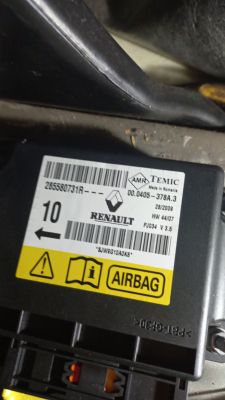 Sterownik airbag marki Renault w samochodzie, etykieta z oznaczeniami.