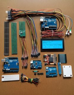 Set of Electronic Components with Arduino Boards Set of electronic components on a brown table, including Arduino boards and multicolored wires.