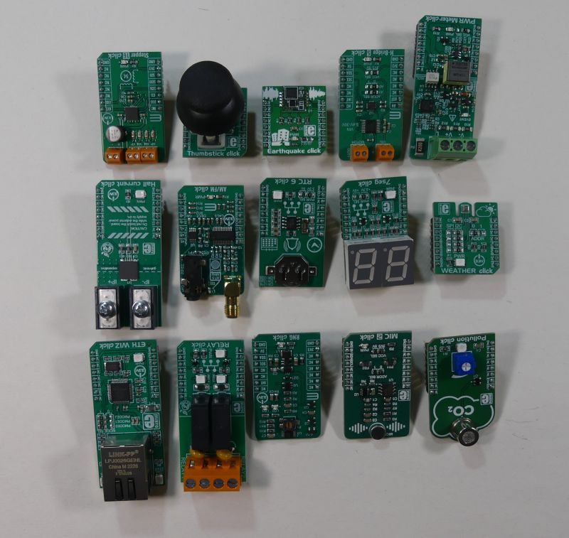 Różne moduły Click Boards leżące na białym tle.