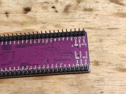 PCB board with pin layout and labels on a wooden background.
