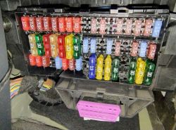 Skrzynka bezpieczników samochodu Volkswagen up! 2018 z różnorodnymi bezpiecznikami.