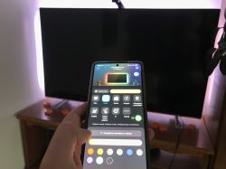 Smartphone with Govee app in front of TV with active LED backlight