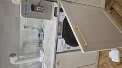 Pęknięty blat nad zabudowaną pralką Haier z wyświetlonym błędem E07