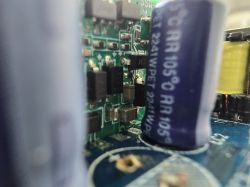 Close-up of electronic components on a circuit board, including an electrolytic capacitor.
