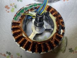 Zbliżenie na rozkręcone koło hulajnogi z widocznymi miedzianymi zwojami i przewodami.