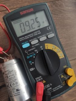 Cyfrowy miernik Sanwa CD772 z odczytem 9.25 µF obok kondensatora Ducati 15 µF.
