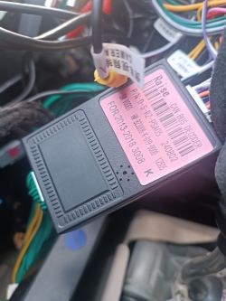 Zbliżenie dekodera CAN BUS z widocznymi przewodami i etykietą z danymi technicznymi.
