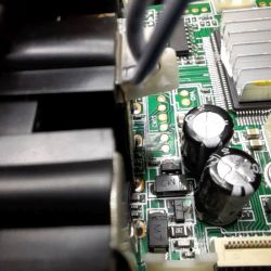 Nahaufnahme einer Leiterplatte mit Lüfter, zwei Elkos und SMD-Bauteilen im SOT-23-Gehäuse