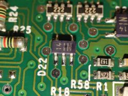 Zbliżenie na płytkę drukowaną z widocznymi elementami elektronicznymi, takimi jak rezystory i diody.