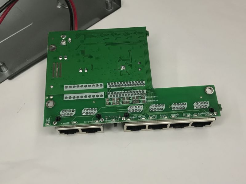 Green switch PCB with six RJ45 ports, viewed from the trace and solder side