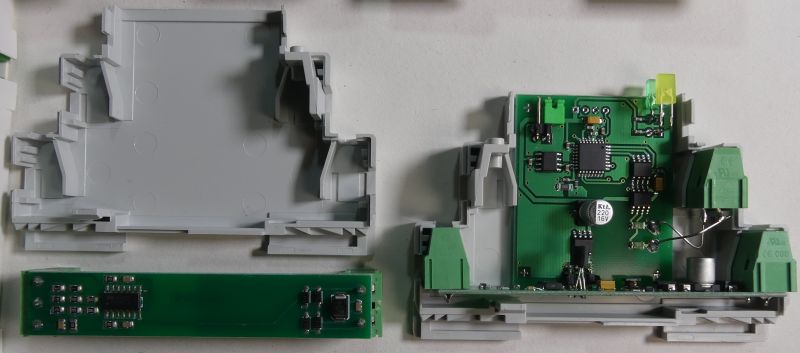 Rozłożona obudowa z widoczną płytką drukowaną i elementami elektronicznymi wewnątrz.